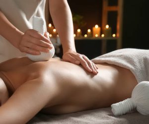 Young woman receiving herbal bag massage in spa salon, closeup Young woman receiving herbal bag massage in spa salon, closeup